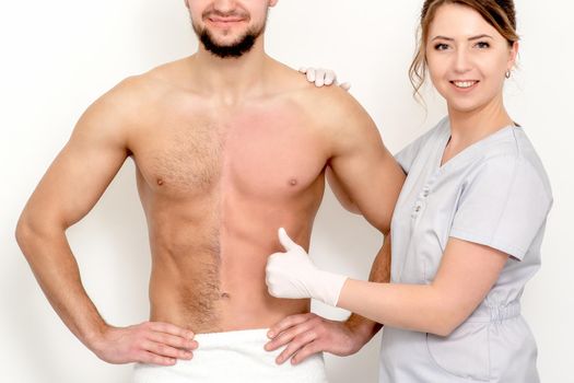 Young caucasian man with bare chested before and after waxing his hair with thumb up of hand of beautician standing on white background