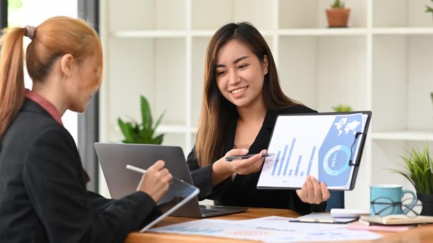 Two young female financial advisor preparing presentation for company clients or investors.