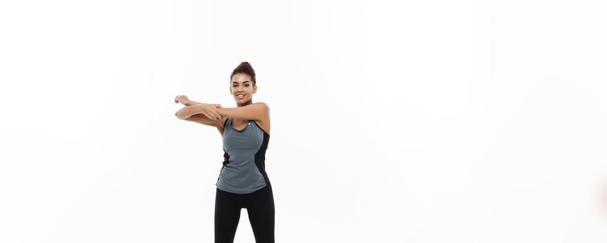 Sport, training, lifestyle and Fitness concept - Full-length portrait of beautiful happy African American woman stretching hands. Isolated on white studio background