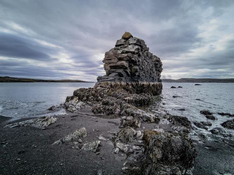 Spectacular boulder to the fjord on low tide under stormy sky