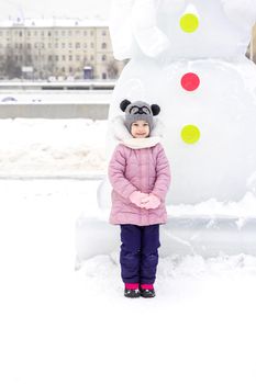 portrait of a cute baby girl in a snowy town on a winter day