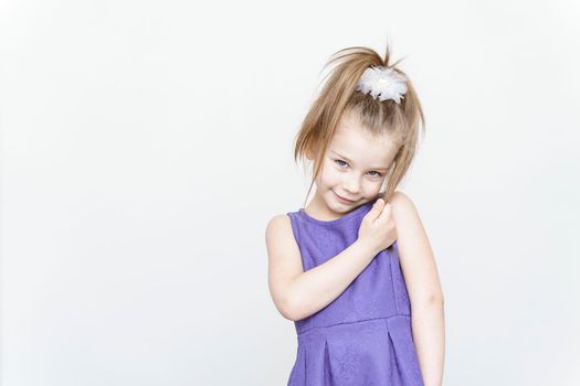 portrait of a cute 5 year old girl on a light background. Interior studio shot on gray background