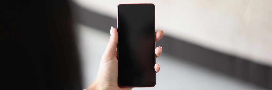 Close-up of woman hold smartphone with locked or turned off black screen. Mobile phone doesnt work, useless device. Mockup, technology concept. Copy space