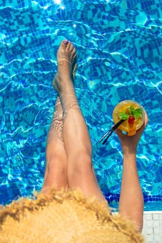 Woman with cocktail near the pool. Selective focus. Drink.