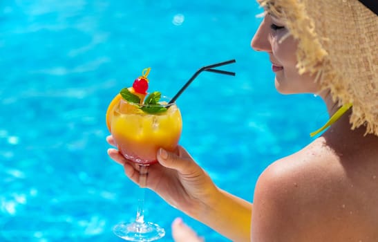 Woman with cocktail near the pool. Selective focus. Drink.