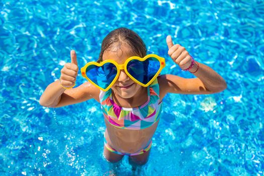 Child in the pool wearing big glasses. Selective focus. Kid.