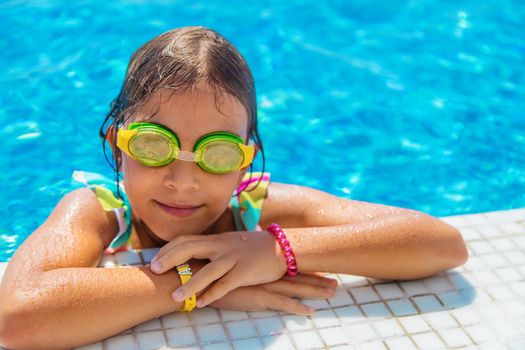 A child with glasses dives into the pool. Selective focus. Kid.