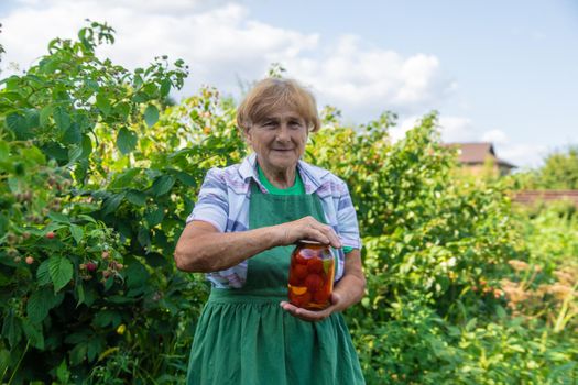 Grandmother canning tomatoes for the winter. Selective focus. Food.