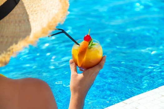 Woman with cocktail near the pool. Selective focus. Drink.