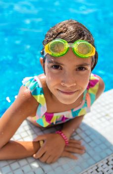 A child with glasses dives into the pool. Selective focus. Kid.