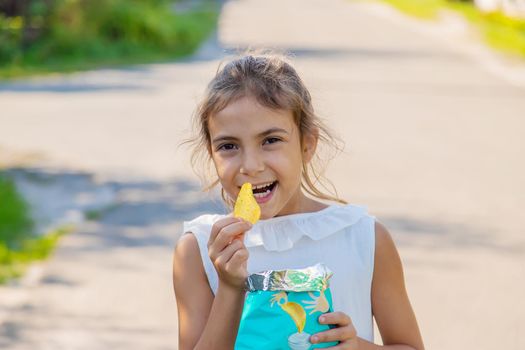 The child is eating chips. Selective focus. Kid.