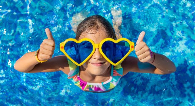 Child in the pool wearing big glasses. Selective focus. Kid.