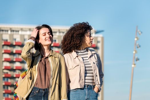 young interracial couple of girls walking around the city holding hands, concept of sexual freedom and racial diversity