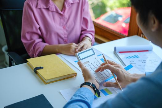 financial, Planning, Marketing and Accounting, Asian young Economist using calculator to calculate investment documents with partners on profit taking to compete with other companies.