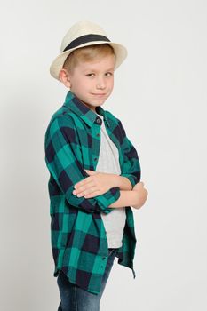 Portrait of cute stylish blond boy kid 7 years old in checked shirt and jeans