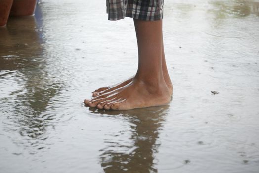 child jumping on water water after rain .