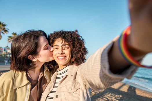selfie photo of young multiracial couple of beautiful lovely girls smiling and kissing, concept of female friendship and racial diversity