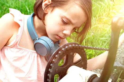 a child girl has damaged a bicycle wheel and is making repairs photo without processing. High quality photo