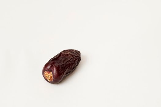 Closeup shot of single dried Safawi date on a white background