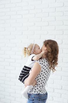 Baby with cochlear implant hearing aid having fun with her mother - deafness and diversity concept. Copy space place for advertising