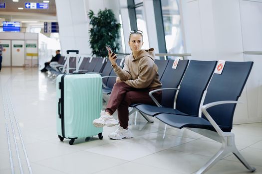 young woman using her smartphone at the airport .Travel Concept.