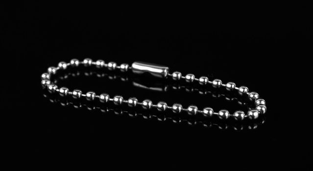 chain for a keychain, on a black background, isolated with reflection