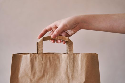 Girl holds an eco-friendly paper bag. Close-up. Shopping bag