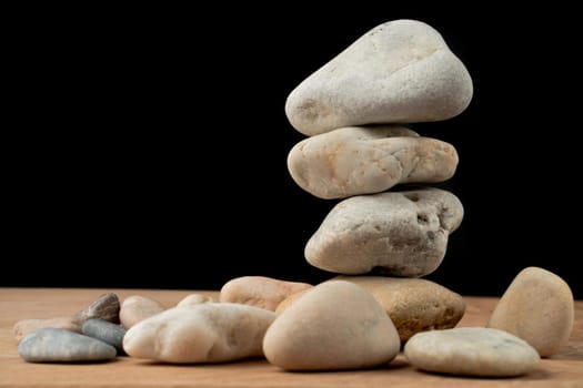 a bunch of smooth stones, on a board on a black background