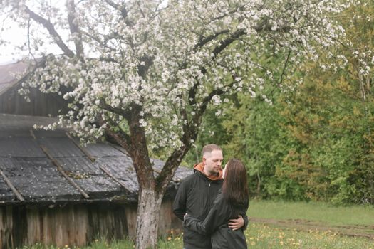 Sensual woman and man in cherry bloom. Couple in love in blossoming garden in spring. Love and romance, relationship, happy family outdoors.