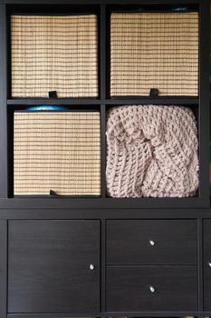 Wicker boxes for things on the shelves. Wardrobe for storage of things. High quality photo