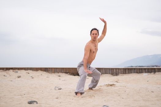 Caucasian man with long hair practicing qigong outdoors