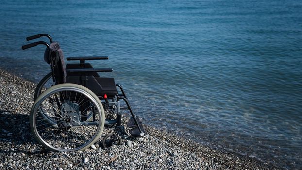 An empty wheelchair on a rocky seashore