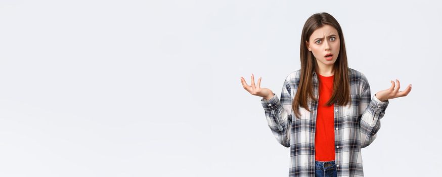 Lifestyle, different emotions, leisure activities concept. Frustrated and confused young woman asking for answers, shrugging with hands spread sideways, stare camera bothered with strange situation.