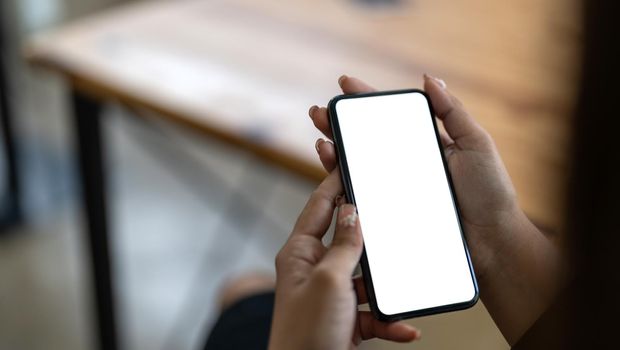 mock up phone in woman hand showing white screen.