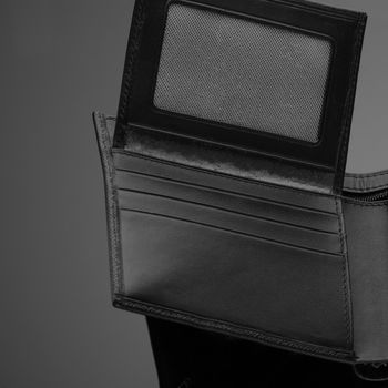 A closeup of a fashionable leather wallet on a dark background