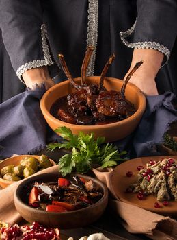 A vertical shot of a waitress presenting a tomahawk steak