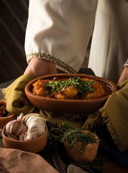 A waitress presenting a chicken stew