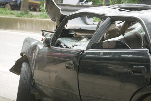 black car damaged by a road accident .