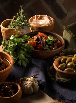 A vertical shot of a chef serving a gourmet salad dish