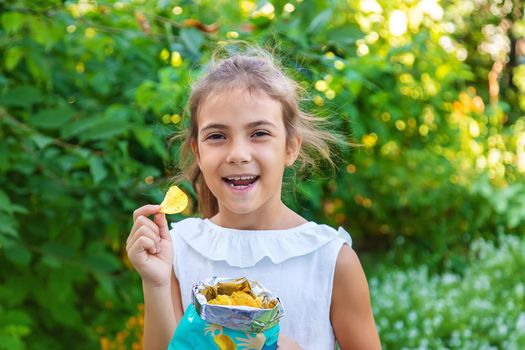 The child is eating chips. Selective focus. Kid.