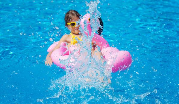 The child swims with a circle in the pool. Selective focus. Kid.