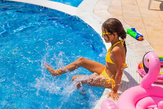 Child Splashes water in the pool. Selective focus. Kid.