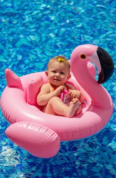 Baby swims in a circle in the pool. Selective focus. Nature.