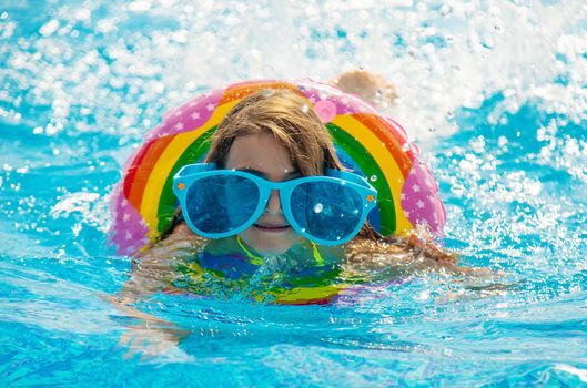 The child is swimming in the pool. Selective focus. Kid.