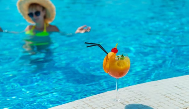 Woman with cocktail near the pool. Selective focus. Drink.