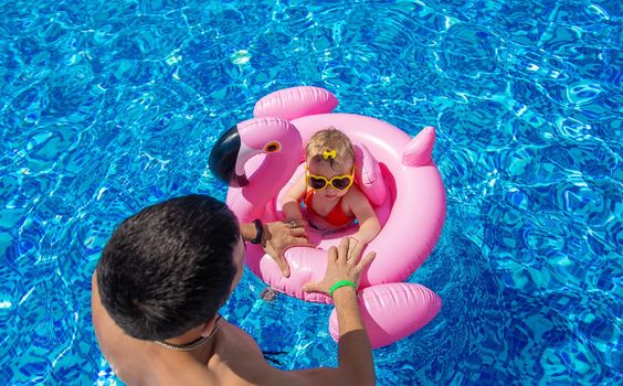 Father with daughters in the pool. Selective focus. Child.