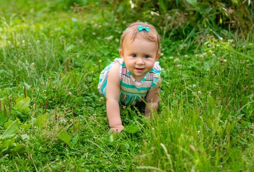 Baby is sitting on the grass. Selective focus. Nature.