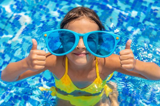 The child is swimming in the pool. Selective focus. Kid.