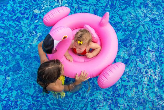 Sister's children swim in the pool. Selective focus. Kid.