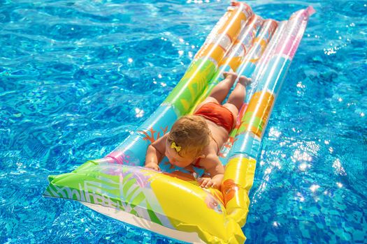 The child is swimming in the pool. Selective focus. Kid.